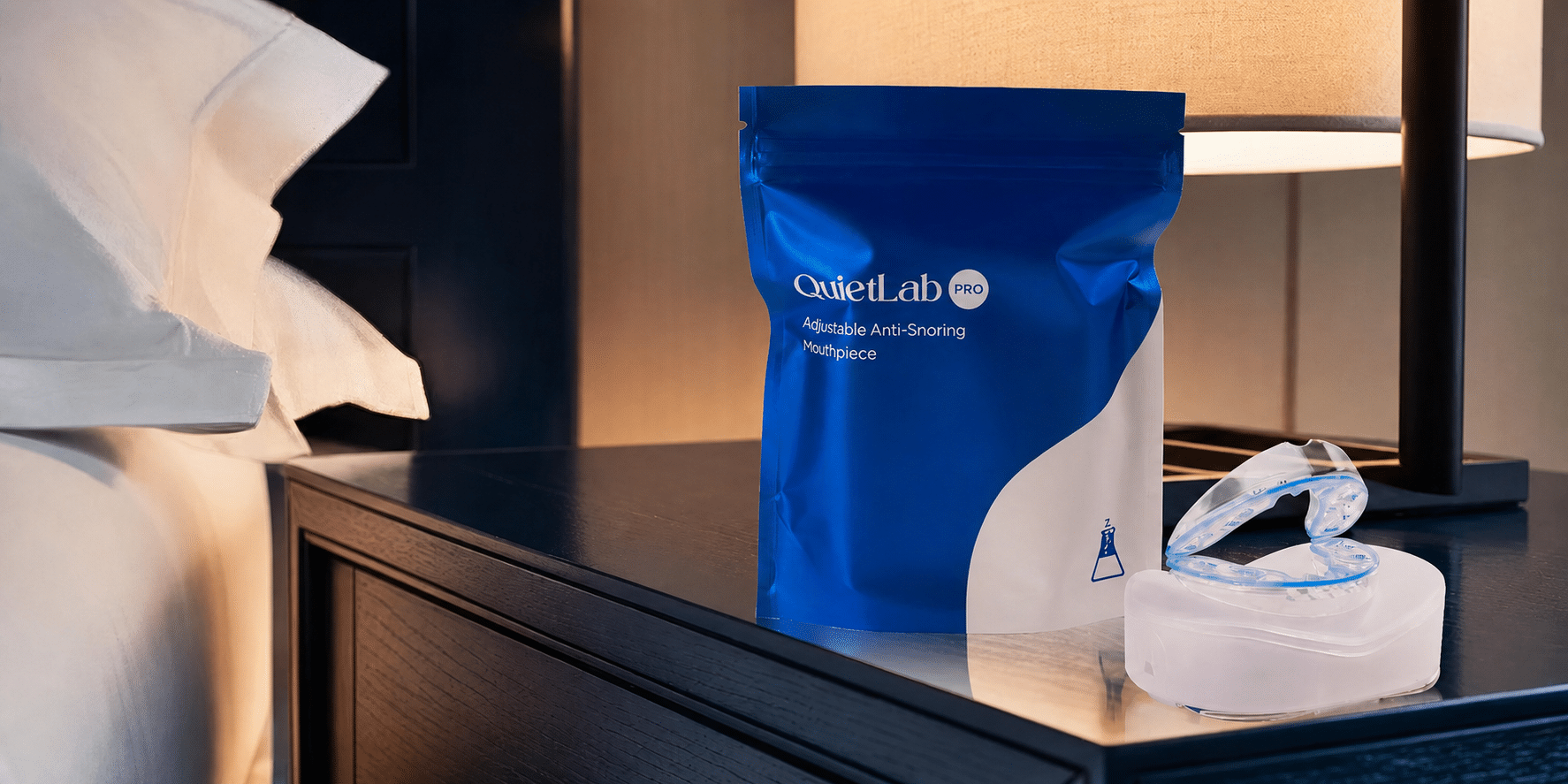 QuietLab mouthpiece, storage case and pouch on a bedside table